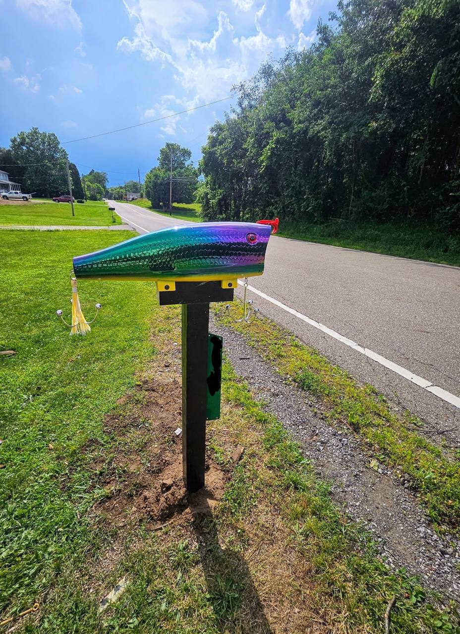 Colorful fishing-lure-shaped mailbox beside the road at The White House of Green